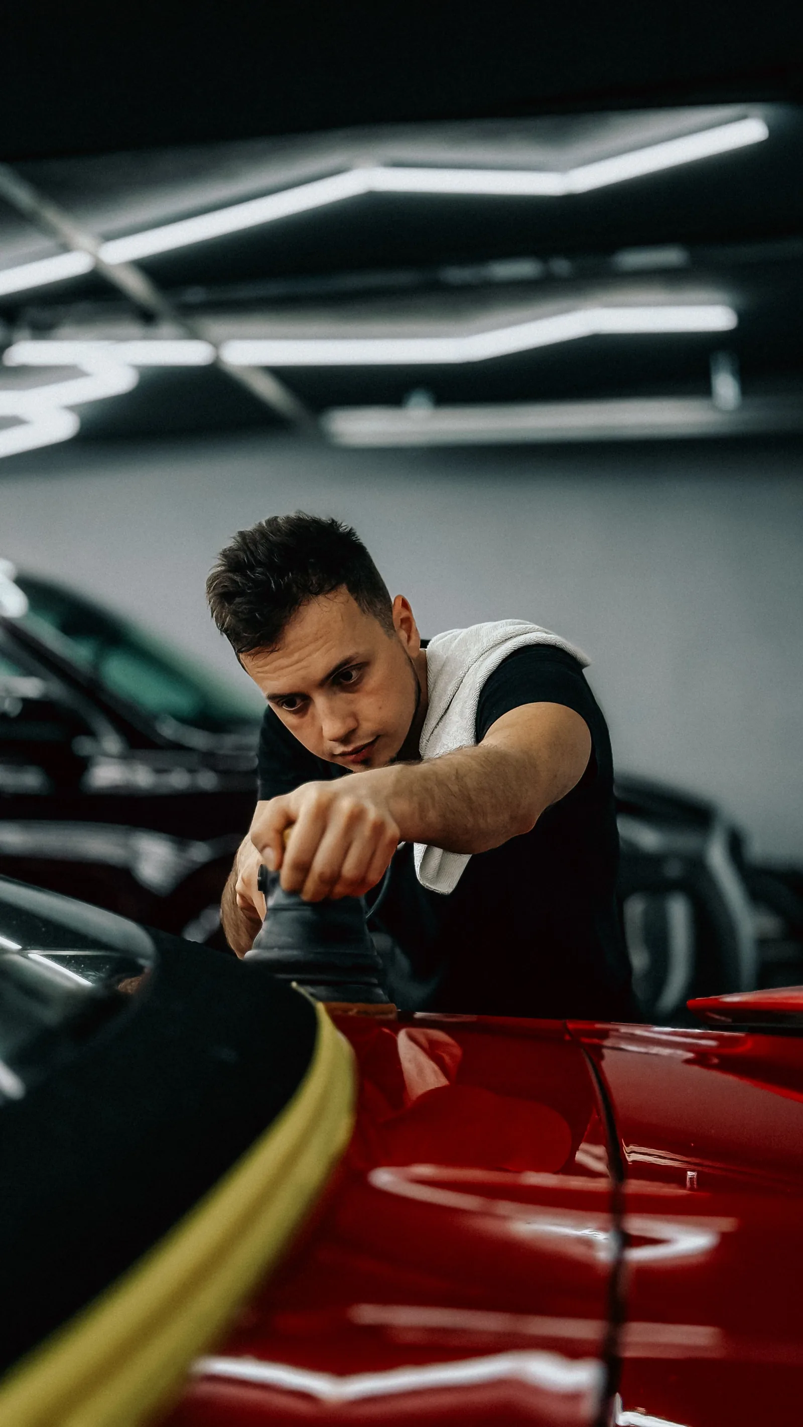 Tom polishing a red car in the studio