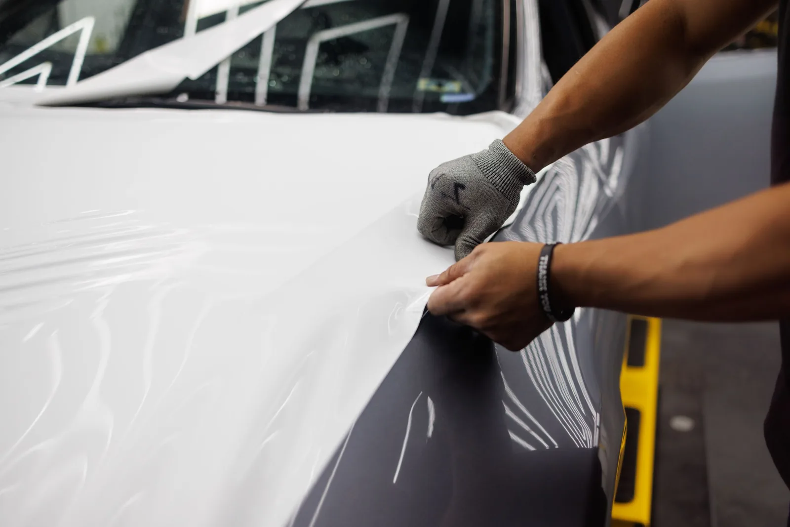 Hands laying the white wrap over the bonnet